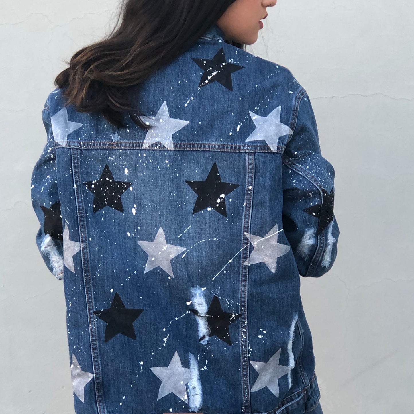 ESTA CHAQUETA TIENE ESTRELLAS PLATA Y NEGRAS Y ESTA CHISPIADA DE PINTURA BLANCA.